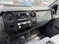 The interior of a 2013 Ford F-550 showing the dashboard with various controls and a stereo system