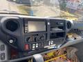 Dashboard of a 2014 Hino 195 featuring a central display screen various controls and buttons along with additional storage compartments