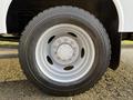 Close-up of a tire and wheel from a 2010 Ford F-550 featuring a silver wheel with multiple lug nuts and a thick black tire with visible tread pattern
