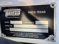 A metal identification plate attached to a vehicle featuring the text "Tymco Waco Texas" along with model details and serial number