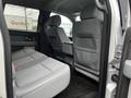 Interior view of the rear seating area of a 2014 Ford F-150 with gray fabric seats and a spacious design