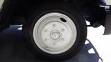 Close-up of a white wheel on a 2004 Freightliner MT45 with multiple lug nut holes and a smooth tire surface