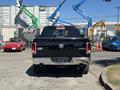 A black 2015 RAM 1500 viewed from the rear showcasing its chrome exhaust tips and tailgate with the RAM logo