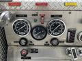The dashboard of a 1995 Freightliner FL086 showing gauges for compound pressure and oil pressure along with controls for throttle and panel lights