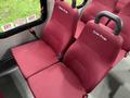 A pair of maroon upholstered bus seats with the names "Darren Poole" and "Ernie Poole" displayed on the seat backs
