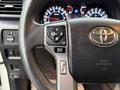 Close-up of a steering wheel with controls including a mode button and a multi-directional pad showcasing the interior features of a 2018 Toyota 4Runner