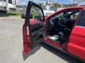 A red 2015 Jeep Grand Cherokee with the driver's door open showcasing the interior and dashboard details