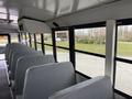 Interior view of a 2022 Freightliner B2 school bus showcasing gray seats arranged in rows with large windows allowing light to enter