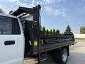 A 2022 Ford F-550 truck with a flatbed and a hydraulic lift system on the rear side