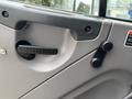 Close-up of the interior door panel of a 2013 Freightliner 114SD showing a handle and a window crank mechanism
