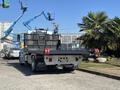 A 2020 Peterbilt 330 tow truck with a flatbed and distinctive red hooks at the rear