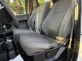 The interior of a 2018 Ford F-350 SD featuring two gray cloth front seats with seatbelts and a console in between