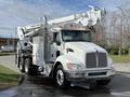 A 2008 Kenworth T370 bucket truck with a white body featuring a raised hydraulic boom and a utility box on the side