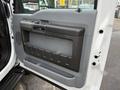 The image shows the interior door panel of a 2012 Ford F-550 featuring a gray armrest and a storage compartment