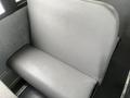 A close-up view of a gray vinyl seat in a bus with a smooth texture and a slightly contoured shape