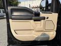 A black and beige interior door panel of a 2021 Ford F-350 SD featuring a handle control panel and textured surfaces