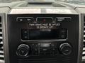 Dashboard controls of a 2018 Ford F-550 featuring buttons for radio settings and a warning message about the park brake for operating the lift