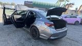A 2018 Hyundai Sonata with both rear doors and the trunk open parked in a lot