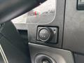 Close-up of a control panel in a 2025 Peterbilt 536 featuring a round black button with iconography and a smaller button adjacent to it