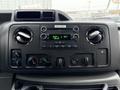 Dashboard of a 2013 Ford E-350 featuring a digital radio display with knobs and controls for climate and audio settings