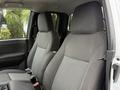 Interior view of a 2012 GMC Canyon showing two front bucket seats with grey fabric upholstery and a simple dashboard design