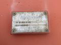 A weathered identification plate labeled Henderson with model and serial numbers attached to a metal surface