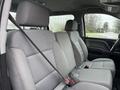 The interior of a 2015 GMC Sierra 1500 featuring two front seats and a spacious second row with seat belts visible