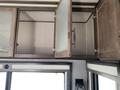A 2021 Grand Design Recreational ST3478MBS cabinet with an open door featuring a mesh design and visible interior space