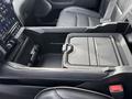 Interior console of a 2021 RAM 1500 with a sleek black design featuring a storage compartment and controls for various functions