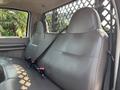Interior of a 2009 Ford F-450 Super Duty showing two leather seats in the backseat with seatbelts attached