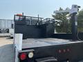 A 2006 Sterling Acterra truck with a flatbed and a boom lift on the side, showcasing a sturdy metal structure and a black finish