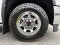 Close-up of a chrome wheel rim with a GMC logo mounted on a rugged Goodyear Wrangler tire showing detailed tread pattern