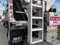 A 2013 Freightliner 114SD featuring a metal ladder attached to the side for access to the top of the vehicle