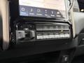 Close-up of the control panel in a 2024 RAM 5500 featuring various buttons for media, comfort, and vehicle settings along with toggle switches for auxiliary controls