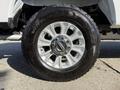 Close-up of a silver alloy wheel with a chrome center cap and a rugged black tire labeled Wrangler All-Terrain Adventure