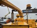 A yellow Bandit 200 wood chipper featuring a funnel-shaped exhaust, control levers, and a rotating beacon light on top