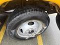 A close-up view of the tire and wheel of a 2021 Ford Econoline showcasing a gray wheel rim and a black tire with prominent tread patterns