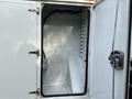 An open compartment of a 2013 International Durastar 4300 revealing a white interior with a fitted shelf and electrical components visible
