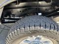 Close-up of a 2022 Ford F-350 SD tire showcasing its rugged tread design and distinct wheel rim with the brand name Outpost embossed on it