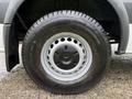 Close-up of a wheel and tire from a 2016 Mercedes-Benz Sprinter focusing on the silver rim with a central three-pointed star logo