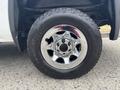 A close-up of a shiny chrome wheel and tire from a 2016 GMC Sierra 1500 featuring a textured black tire and prominent lug nuts