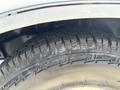 Close-up of a tire on a 1995 Ford F-250 with a rugged tread pattern and visible wear marks on the rubber surface