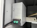 A silver metal control box with two green buttons labeled close and open mounted on a vertical surface