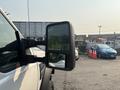 A 2009 Ford F-550 with a side mirror prominently displayed in the foreground