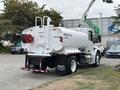 A 2025 Peterbilt 536 water truck with a white tank marked for 2000 gallons and red hose attachment at the back