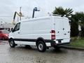 A 2017 Mercedes-Benz Sprinter van with a white exterior and black trim parked at an angle showing its rear and side view