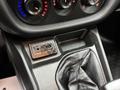 A close-up view of the center console in a 2017 RAM ProMaster City featuring climate control dials an AUX port and a leather-covered gear shift