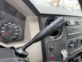 A close-up of the gear shift lever in a 2008 Ford F-250 SD with a speedometer and dashboard controls visible in the background