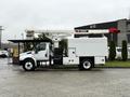 A 2020 International MV607 utility truck equipped with a Terex aerial work platform and storage compartments on the side