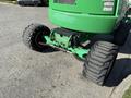 A 2015 JLG 450AJ lift showing the rear wheel assembly with large rubber tires and a green undercarriage